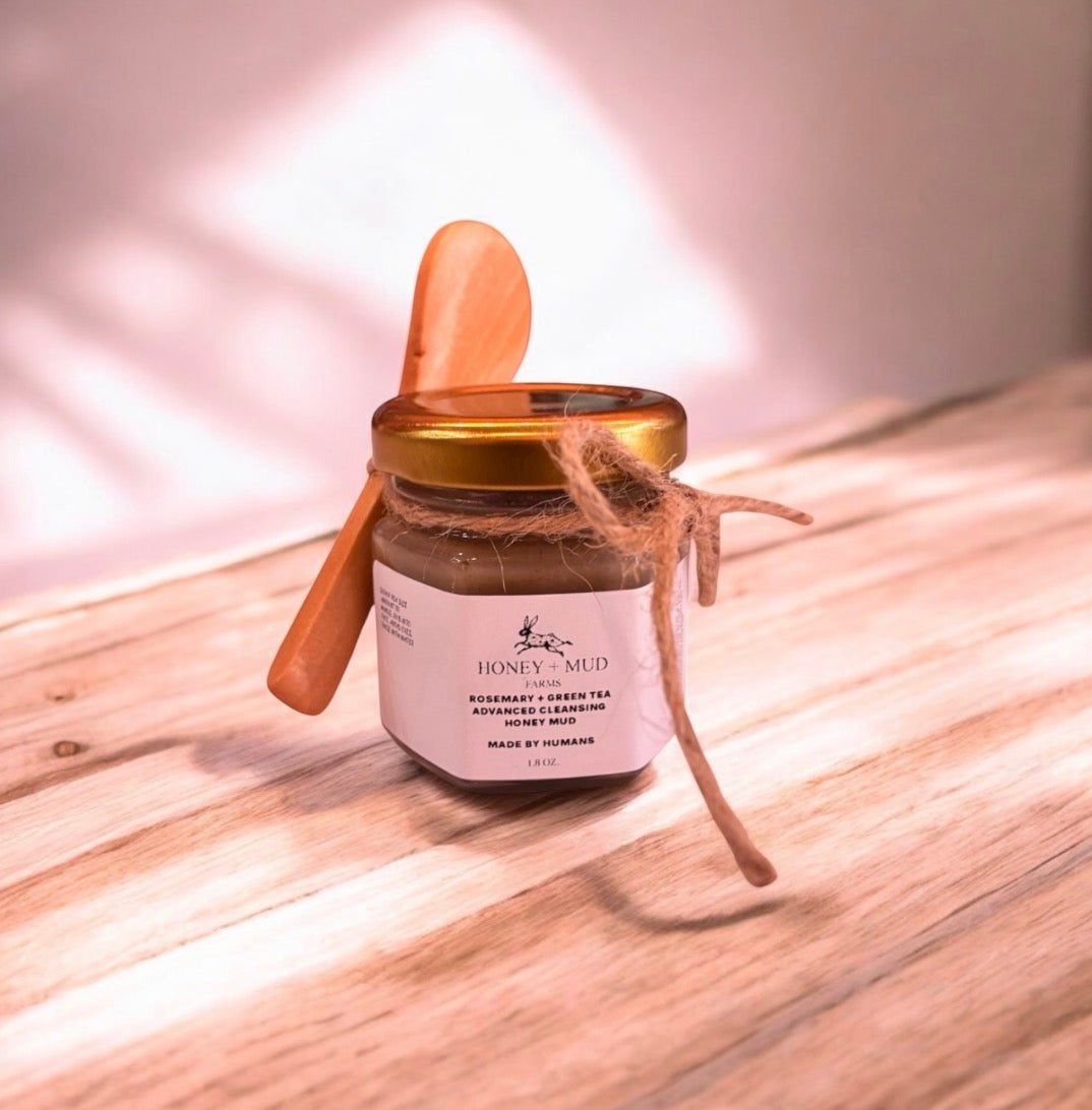 Jar of facial cleanser with a wooden spoon on a wooden surface